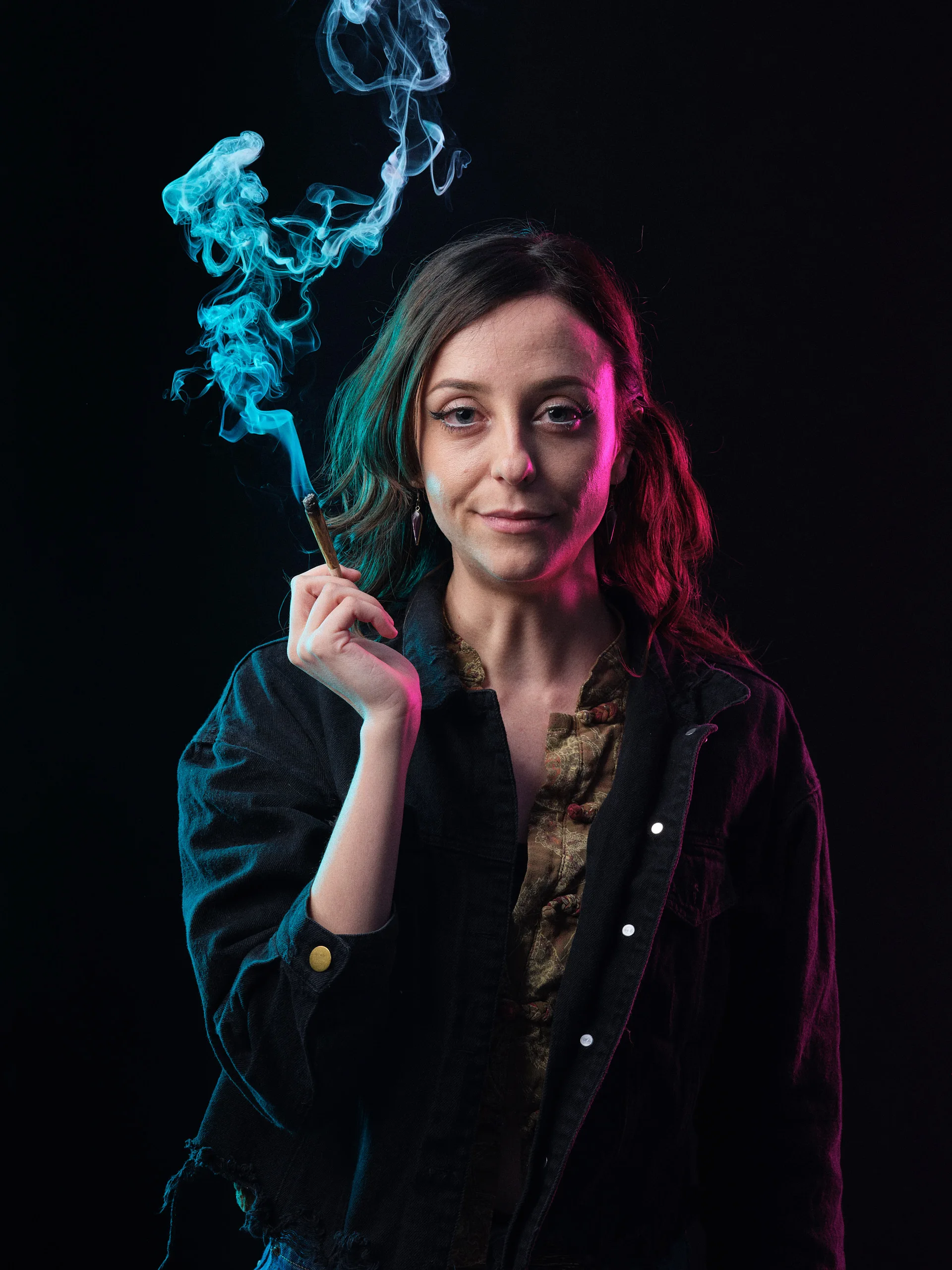 Direct gaze character portrait of a woman holding a smoking joint, illuminated by teal and magenta rim lighting and Broncolor Para 133 key light, high-fidelity GFX medium format capture.