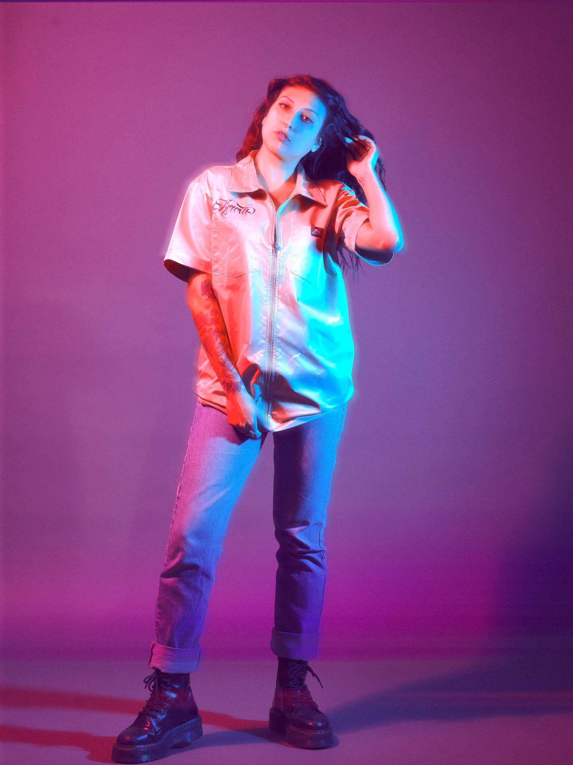 Technical studio fashion portrait by San Francisco photographer; woman in a Ben Davis satin work shirt with intentional motion blur, featuring cyan and magenta gelled lighting and a GFX medium format capture.